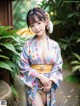 A woman in a blue kimono posing for a picture.