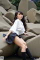 A woman sitting on top of a pile of rocks.