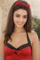 A woman in a red and black bathing suit posing for a picture.